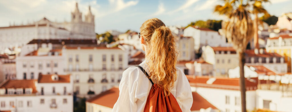 Hotel guest in Portugal looking at sunny city landscape