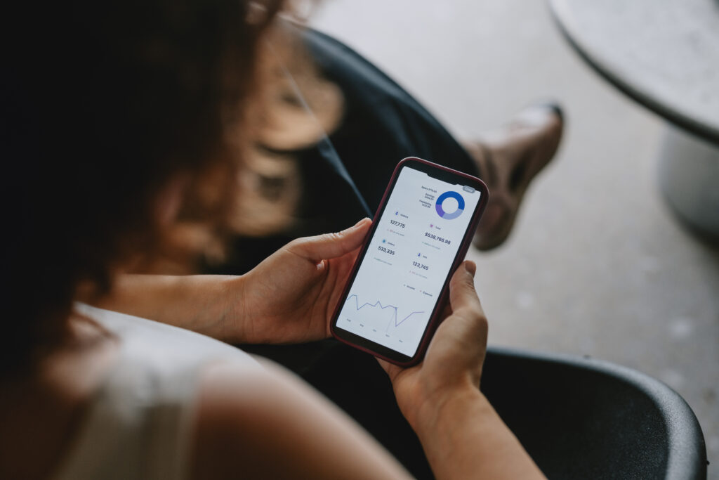 Woman looking at graphs, charts, and numbers on her phone.