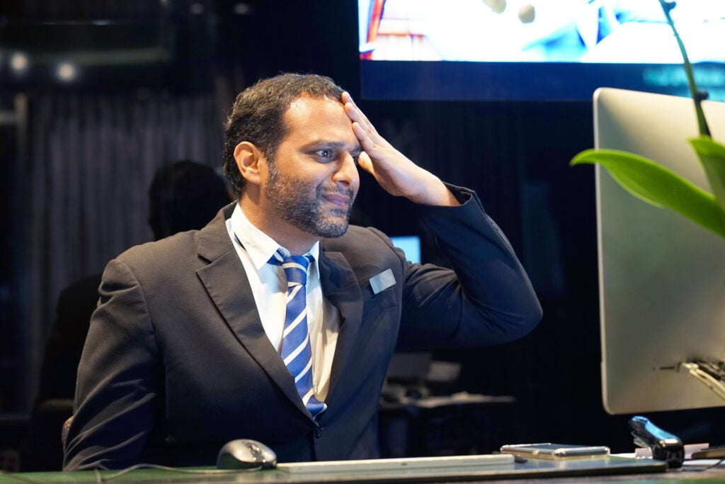 Stressed hotel manager looking at his computer display.