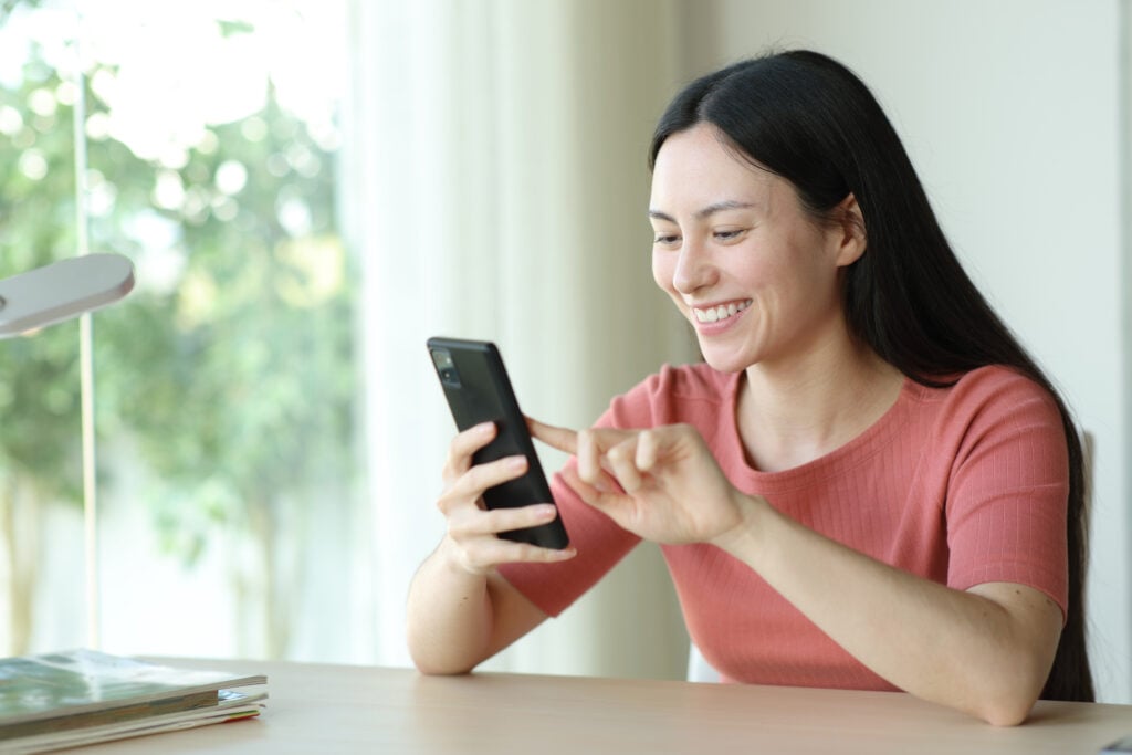 Smiling woman using her phone.