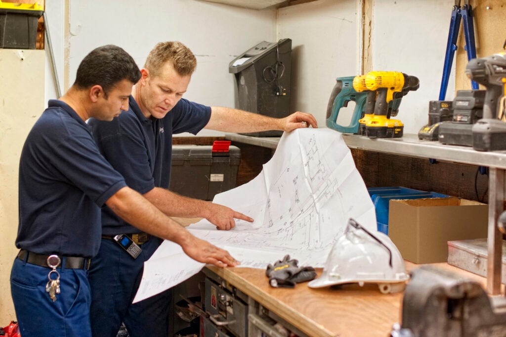 Two engineers studying a blueprint.