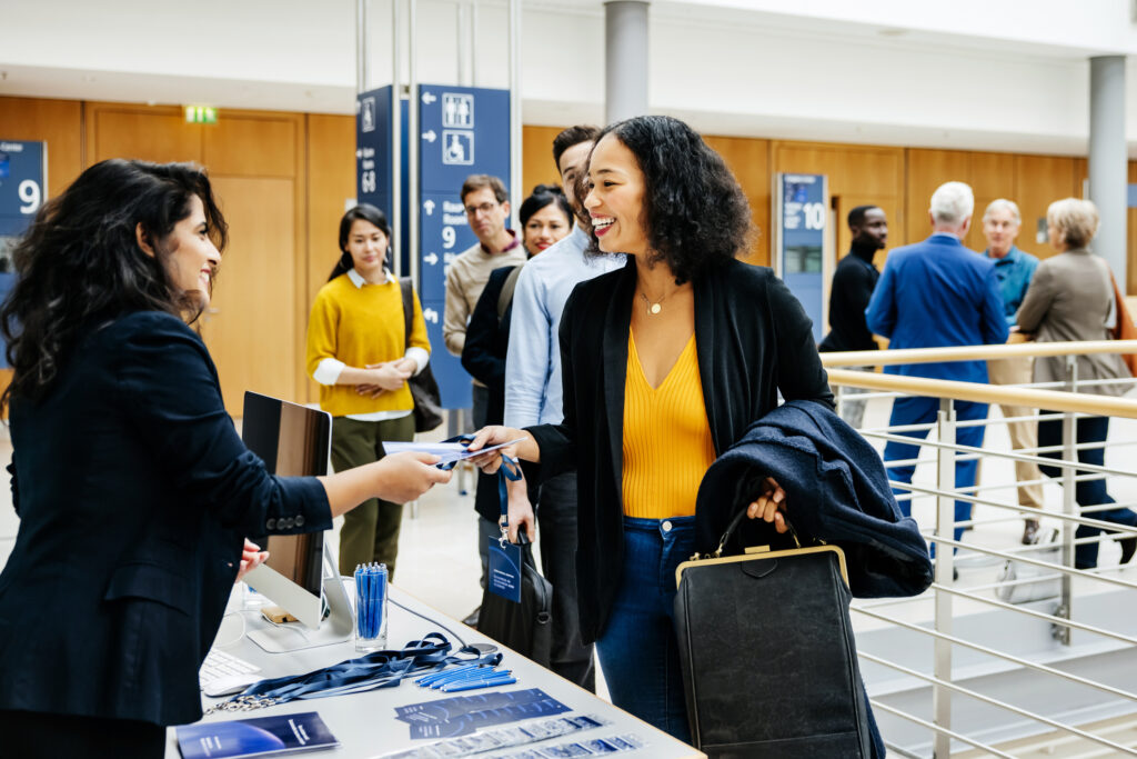 Corporate attendees registering for a conference.
