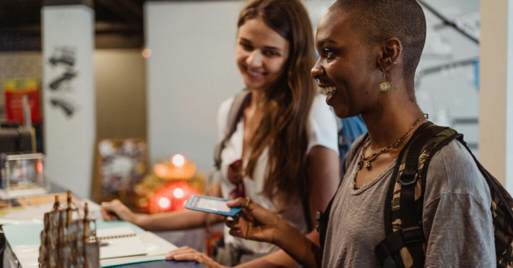 Two women smiling and checking in at hotel reception